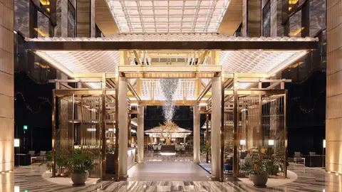 Grand lobby entrance with crystal chandelier and gilded columns at Hotel Okura Manila