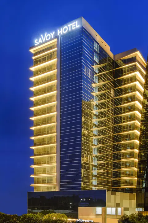 Savoy Hotel Bayshore tower illuminated at night in Mactan, Cebu