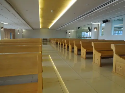 Rows of timber pews under cove lighting in the Shangri-La Plaza Mall chapel